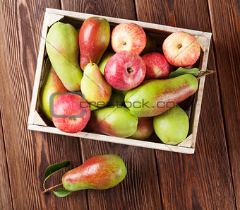 Pears and apples in wooden box on table
