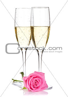 Two champagne glasses and pink rose flower