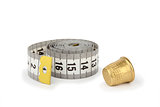Gray measuring tape and thimble on white