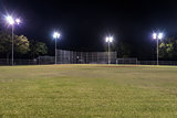Empty baseball field at night with the lights on