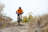 Cyclist Riding Bike on the Beautiful Autumn Mountain Trail