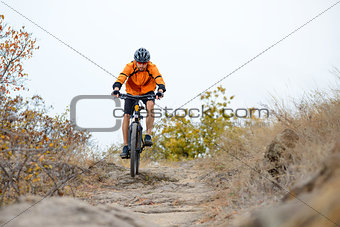 Cyclist Riding Bike on the Beautiful Autumn Mountain Trail