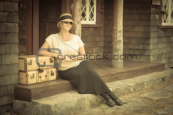 1920s Dressed Girl and Suitcases on Porch with Vintage Effect