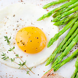 Green asparagus,fried egg and bread with butter.