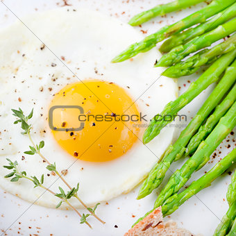 Green asparagus,fried egg and bread with butter.