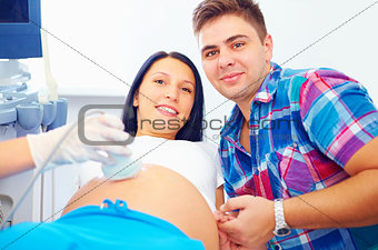 happy pregnant couple on ultrasound diagnostic