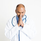 Mature Indian doctor praying