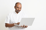 Mature Indian man using laptop