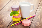 Colorful macaron cookies and cup of milk