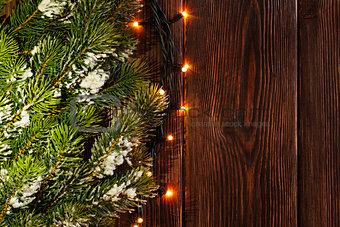 Christmas tree branch and lights on wood