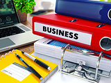 Business on Red Ring Binder. Blurred, Toned Image.