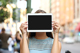 Showing a blank tablet screen covering her face