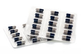 Dark blue and white capsules in medication blister packs.
