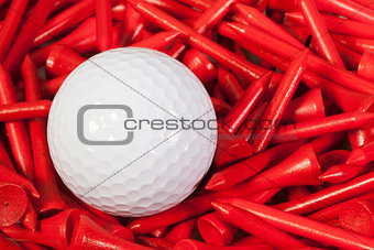 White golf ball lying between wooden tees