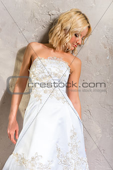 Vertical portrait of the bride standing near a wall