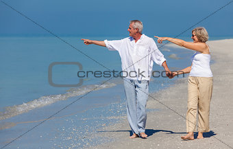 Happy Senior Couple Walking Pointing Holding Hands Beach