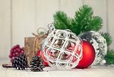 Christmas balls with branch fir and pinecone on wooden board