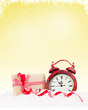 Christmas gift box and alarm clock in snow