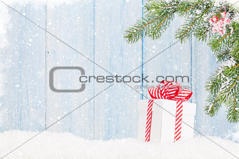 Christmas gift box and fir tree branch in snow