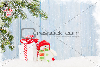 Christmas gift box, snowman toy and fir tree branch
