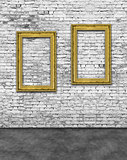 Two vertical golden frames on brick wall