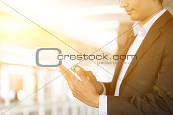 Businessman using tablet computer at train station