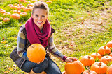 Portrait of smiling woman holding pumpkins on farm