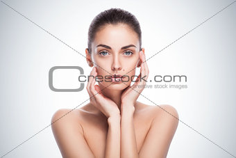Portrait of female model with her hands near face