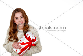 Christmas woman holding present excited.wearing santa hat looking to side showing gift isolated on white background. Beautiful young woman.