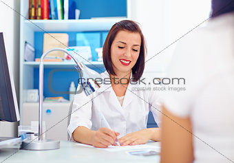 female doctor writes the prescriptions to patient