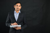 indian business man with a tablet and dark background