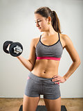 Beautiful young woman doing dumbbell curl
