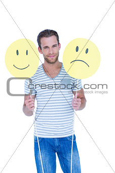 Handsome man holding smiley faces