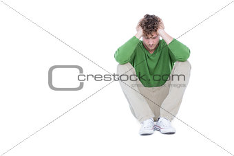 Sad casual man sitting with hand on head