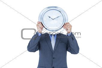 Businessman hiding his face with white clock