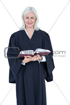 Happy lawyer looking at camera and holding law code
