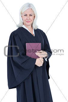 Happy lawyer looking at camera and holding law code