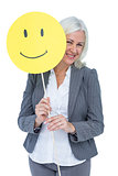 Businesswoman holding happy smiley face