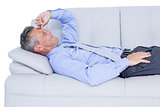 Tired businessman lying on the sofa