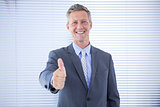 Smiling businessman giving thumbs up at the camera