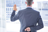 Businessman making a oath while crossing fingers