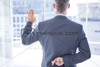 Businessman making a oath while crossing fingers