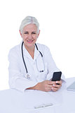 Thinking woman doctor phoning with her smartphone