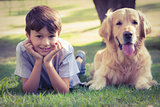 Little boy looking at camera with his dog in the park