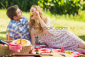 Young couple eating grapes at a picnic