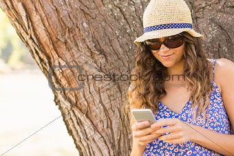 Pretty brunette texting in the park