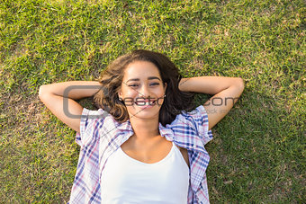Pretty brunette relaxing in the grass