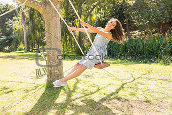 Pretty brunette swinging in park