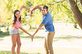 Cute couple doing heart shape with their hands
