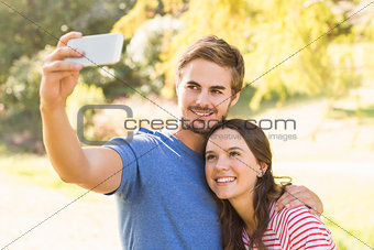 Cute couple doing selfie in the park